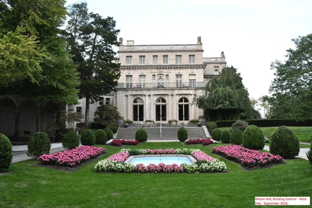 grand, symmetrical, and richly decorated historical mansion, with classical elements surrounded by a garden
