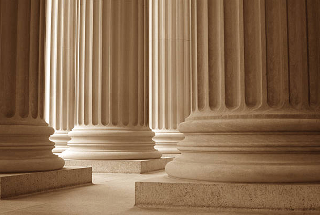 large classic white pillars with light softly shining on them from the left